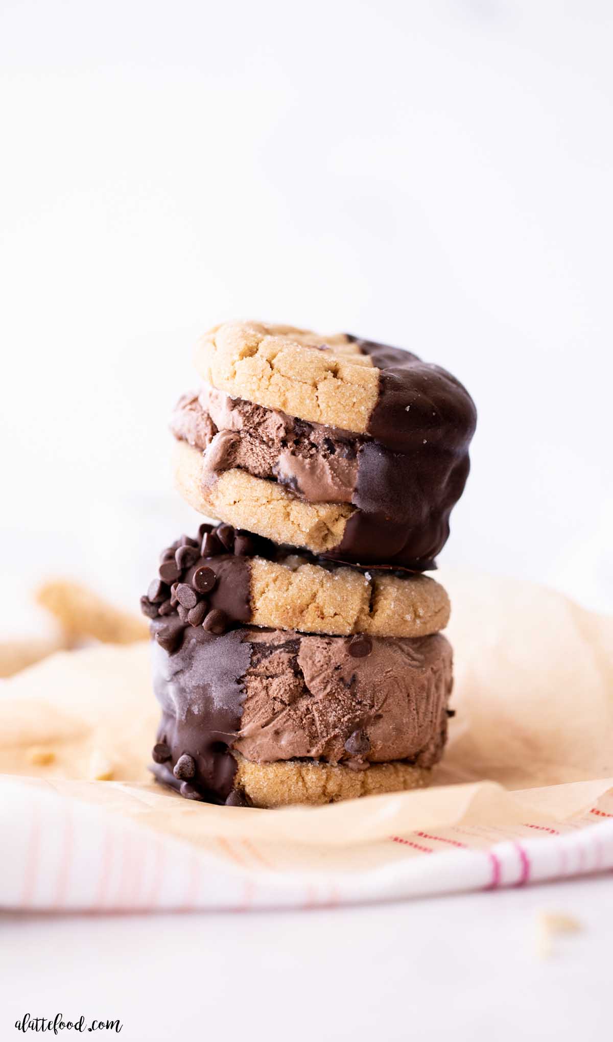 two chocolate peanut butter ice cream sandwiches stacked on top of each other