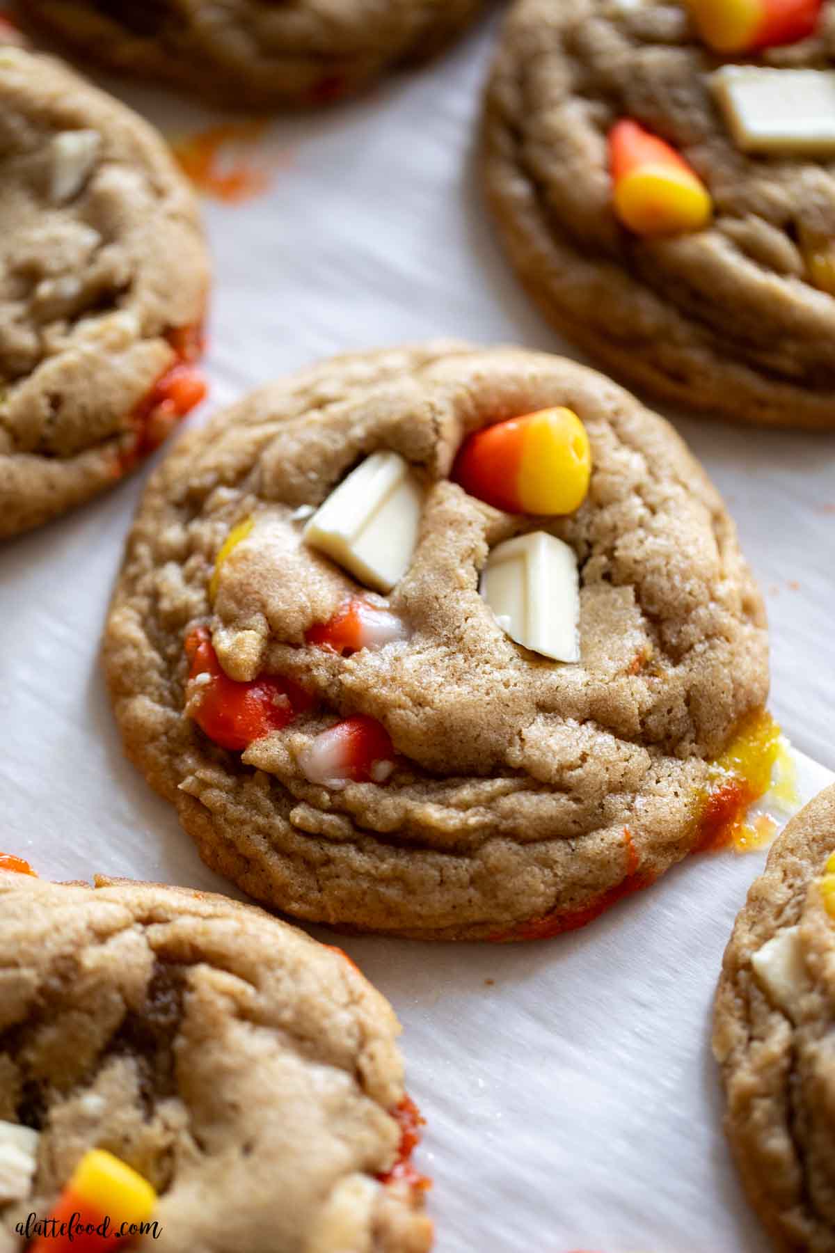 white chocolate chunk candy corn cookies on parchment paper.